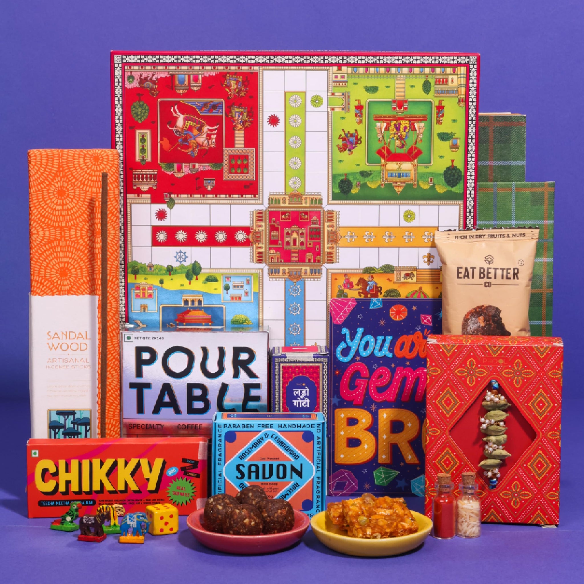 Phool Ludo Rakhi Gift Hamper for Brother | 13-Item Rakhi Gift Box with Elaichi Rakhi, Coffee, Laddoo, Chikki, Soap & Ludo Gam
