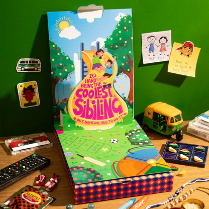 Phool Nostalgia Rakhi Gift Hamper for Brother | 11-Item Rakhi Gift Box with 2 Rakhis, Tic Tac Toe, Incense, Laddoo & Chikki |